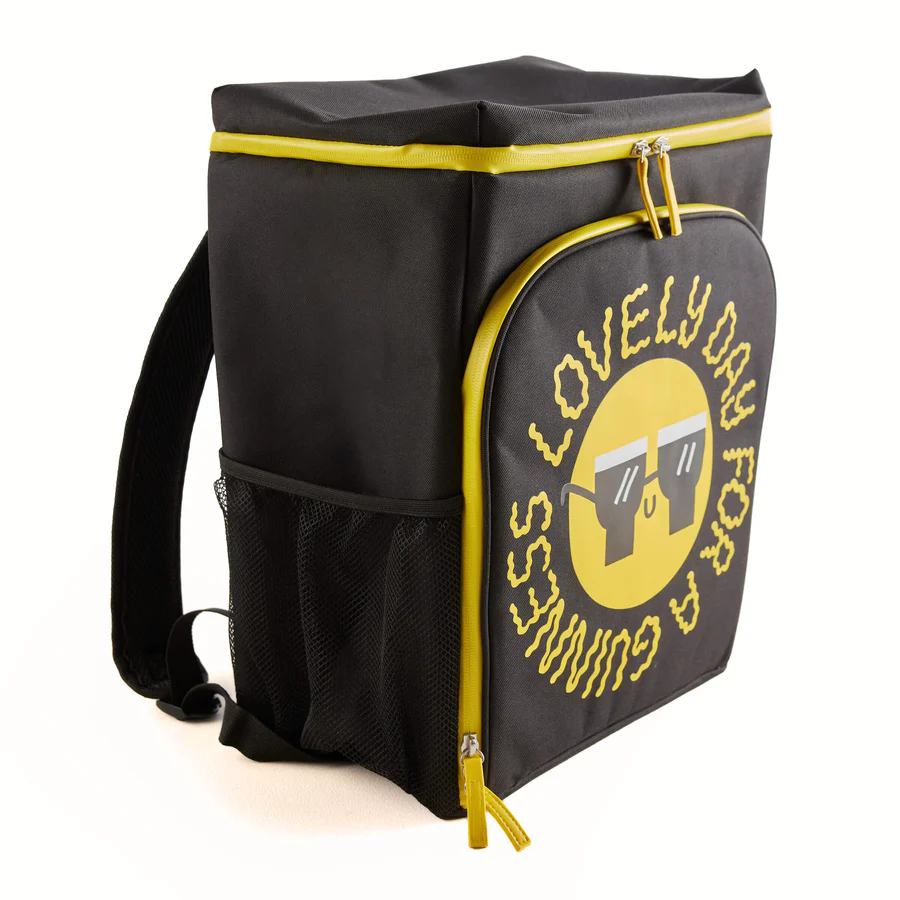The Guinness x Fatti Burke Sun Cooler Bag by Guinness Webstore UK is a black and yellow backpack with a mesh side pocket, large front pocket, and "Lovely day for a Guinness" around a smiling face with beer glass sunglasses.