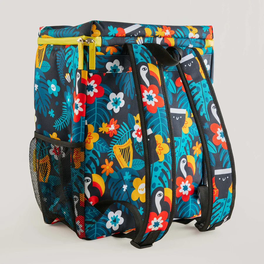 The Guinness x Fatti Burke Hawaiian Cooler Bag from Guinness Webstore UK features a colorful floral and toucan pattern, black straps, a mesh side pocket, and a yellow top zipper inspired by Fatti Burke Illustrations.